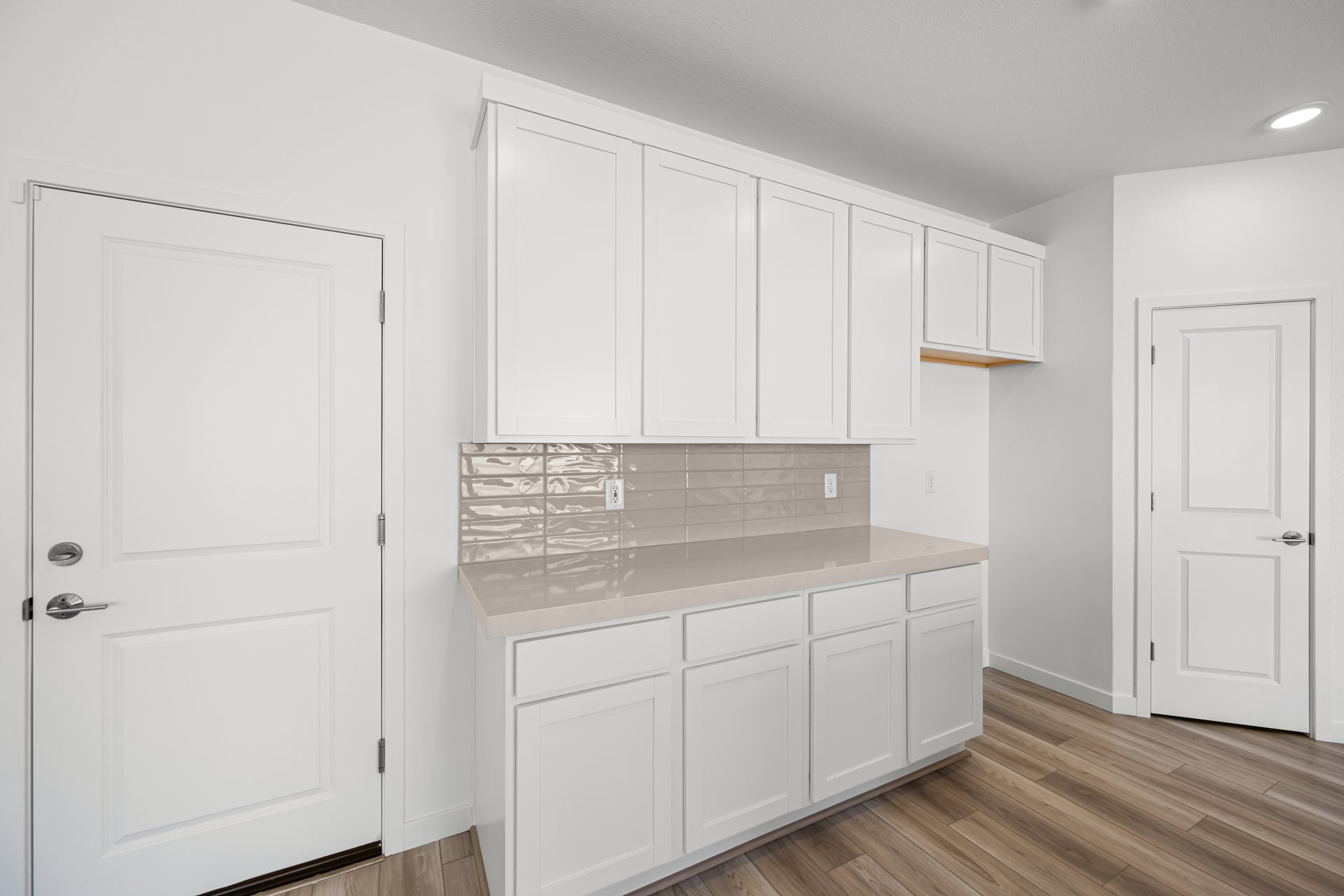 A kitchen with white cabinets.