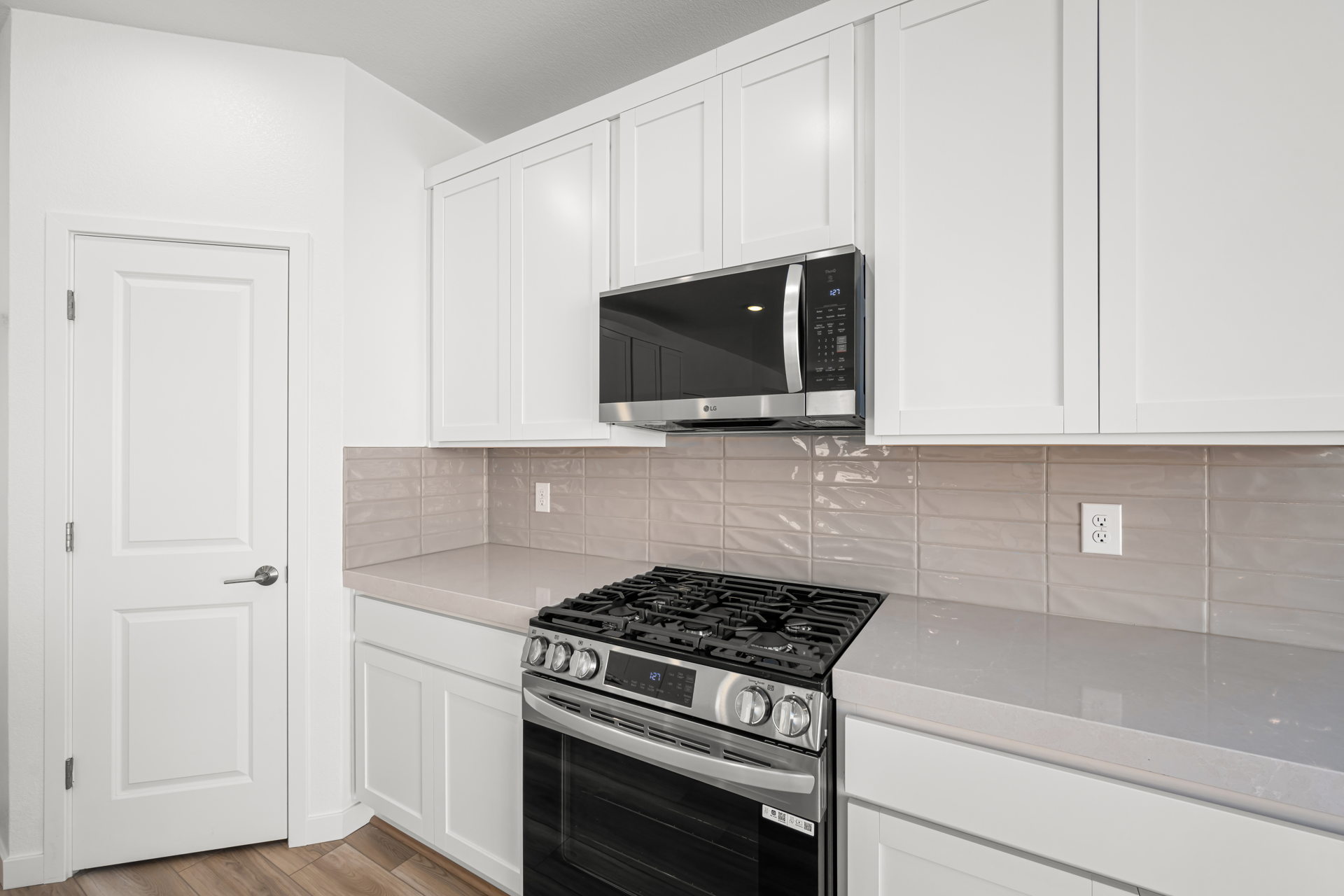 A kitchen with white cabinets.
