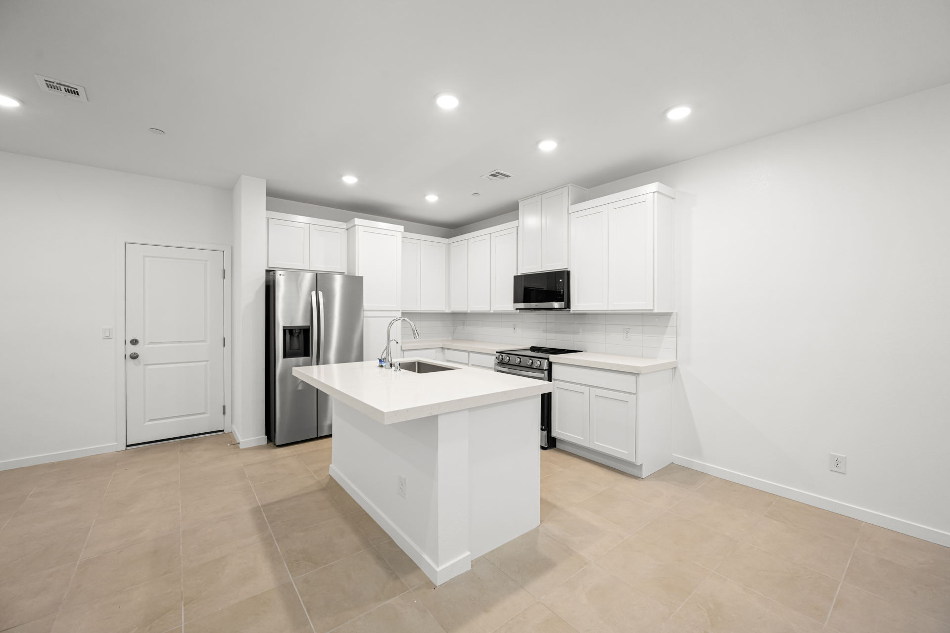 A kitchen with white cabinets.