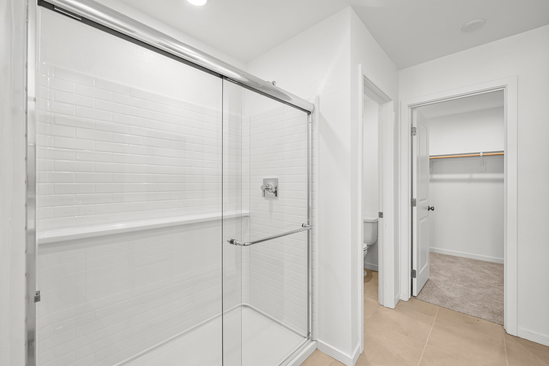 A bathroom with a shower unit and toilet.