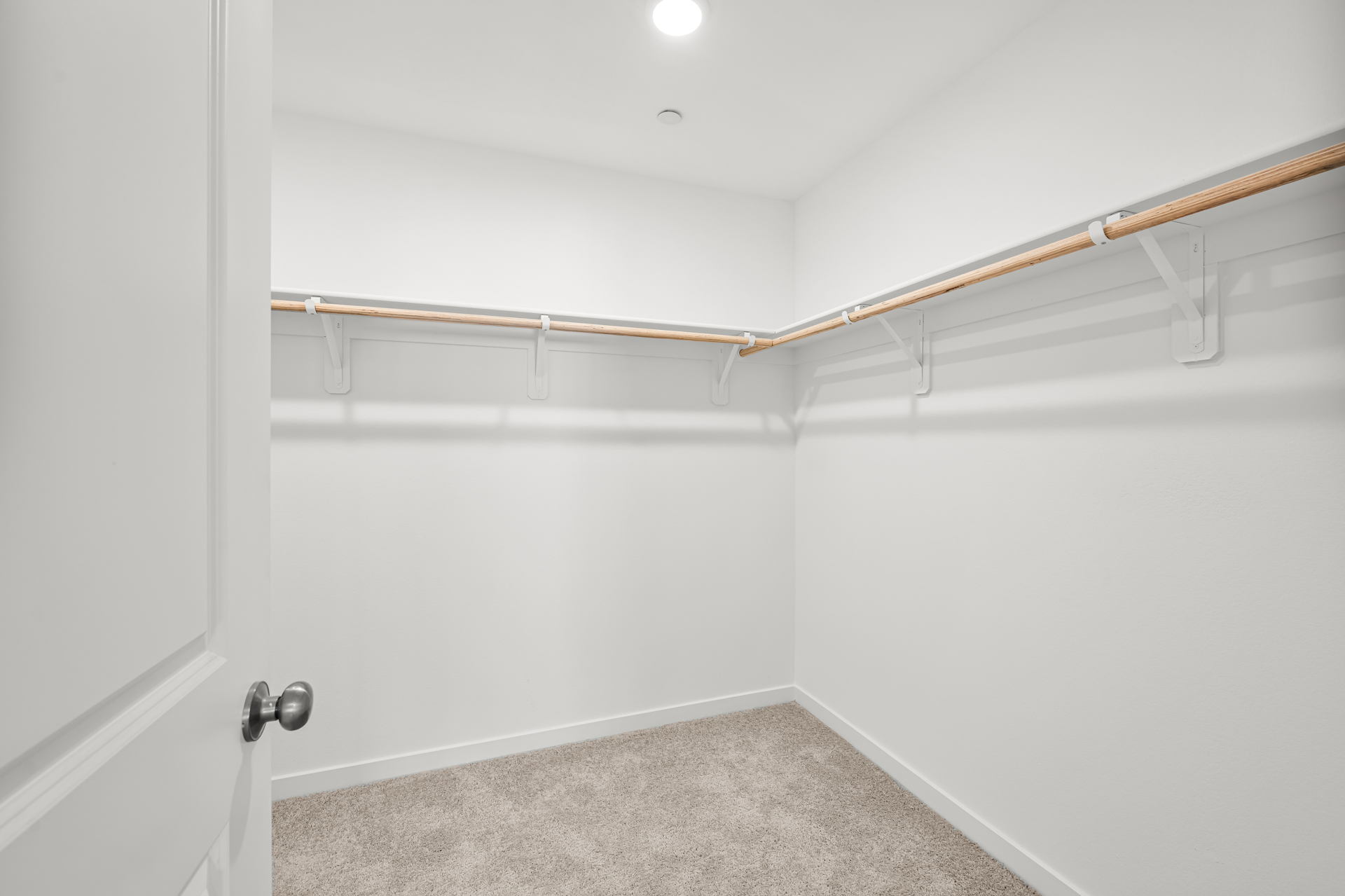 A white room with a metal bar.