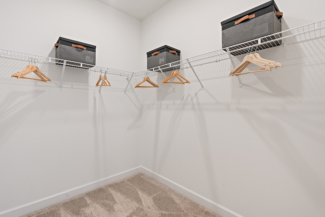 A white wall with a few wooden benches and a few black boxes.