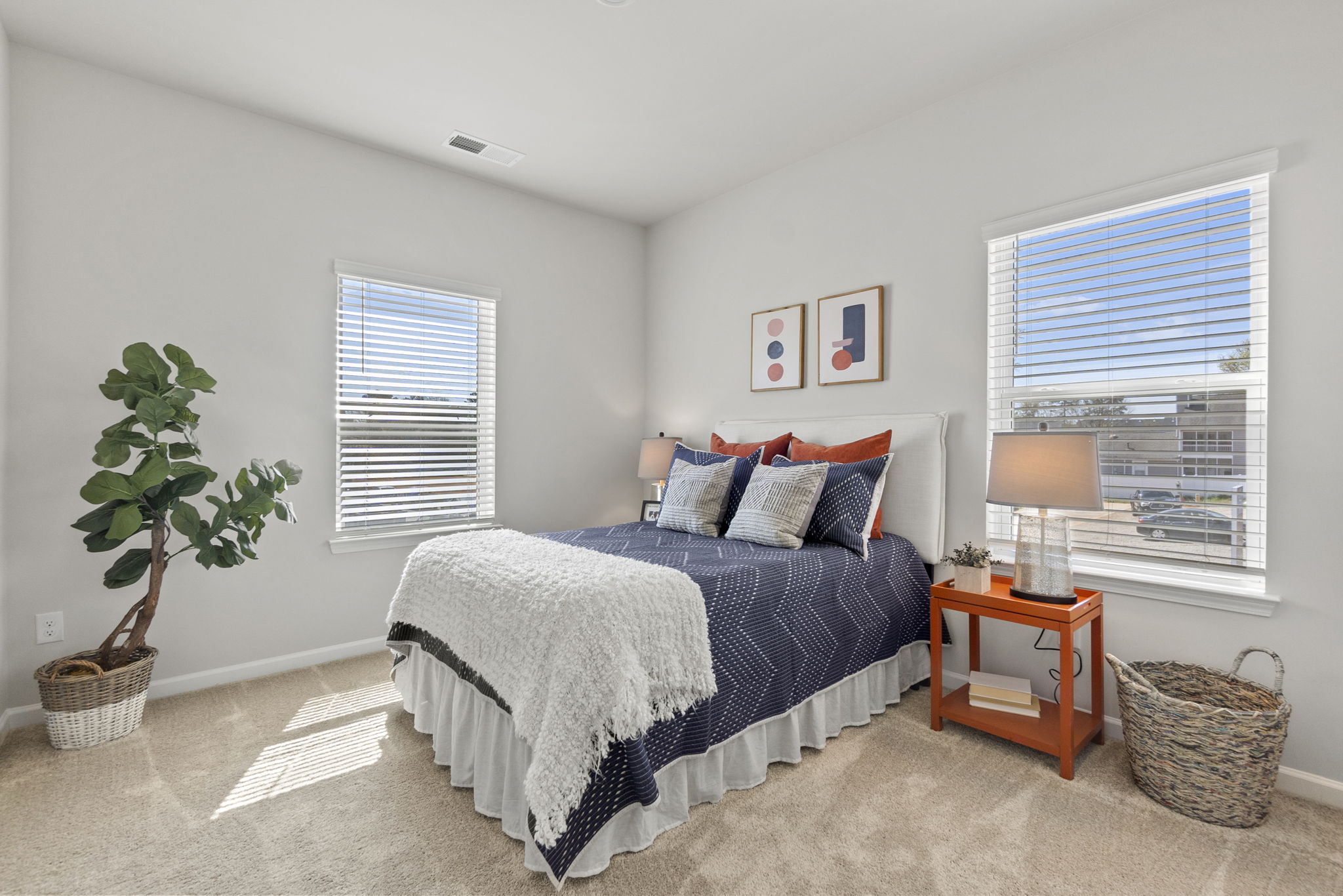 A bedroom with a bed and a plant.