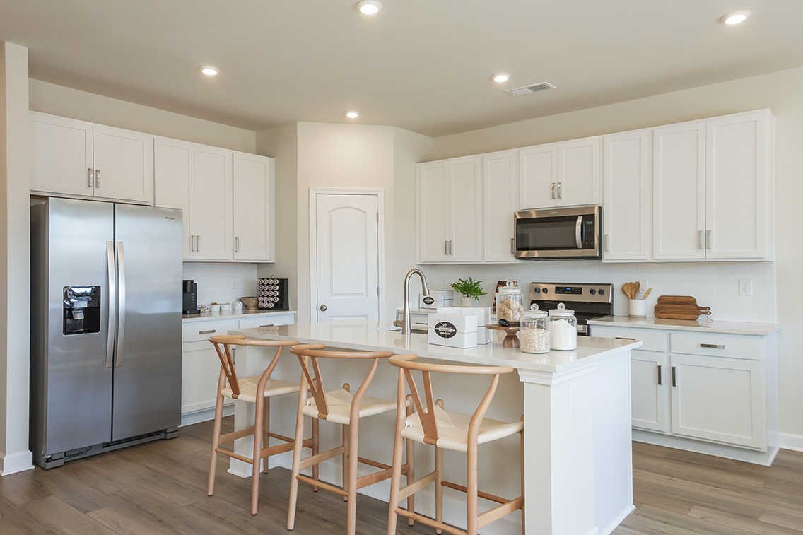 A kitchen with white cabinets.
