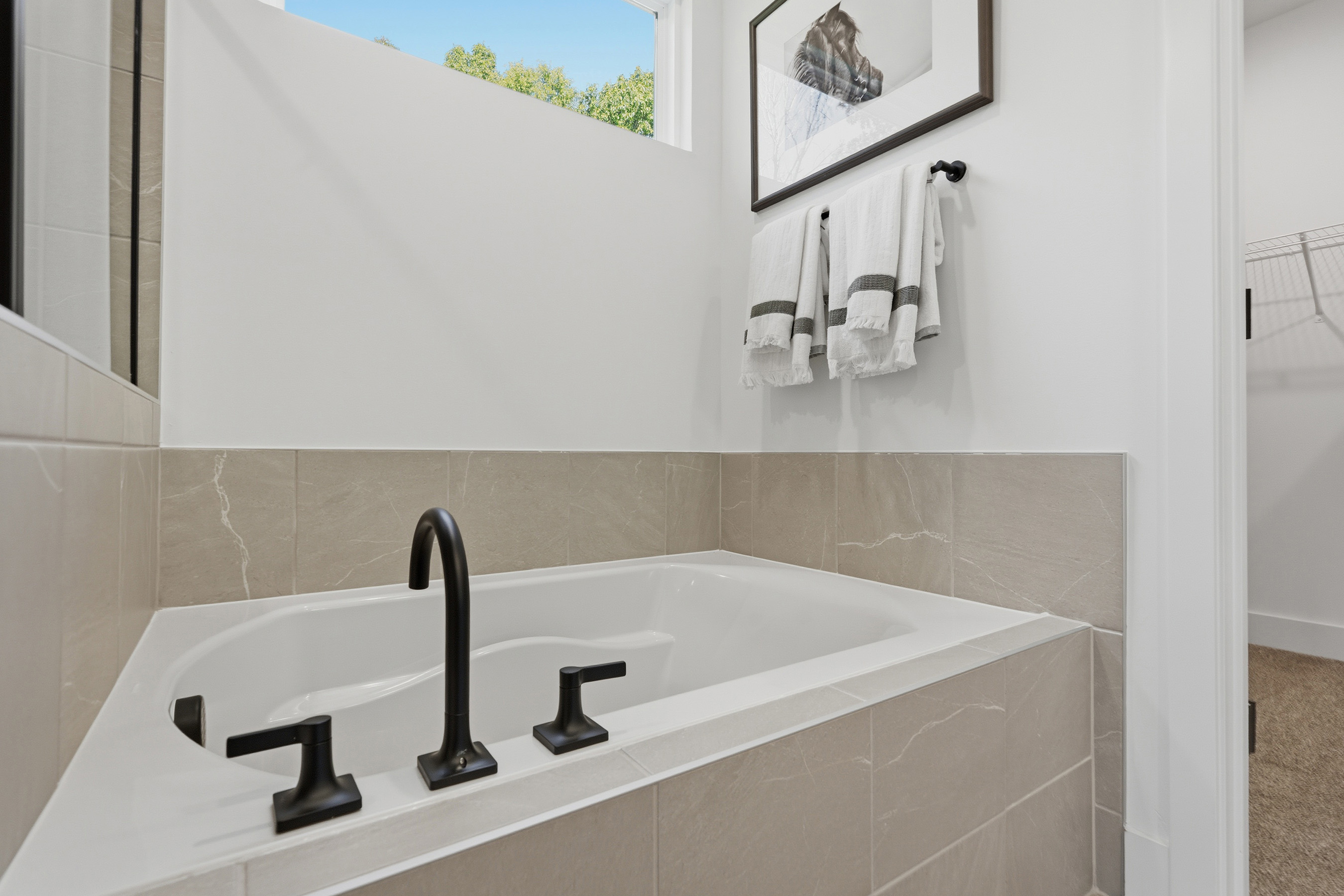 A bathtub with a towel on the wall.