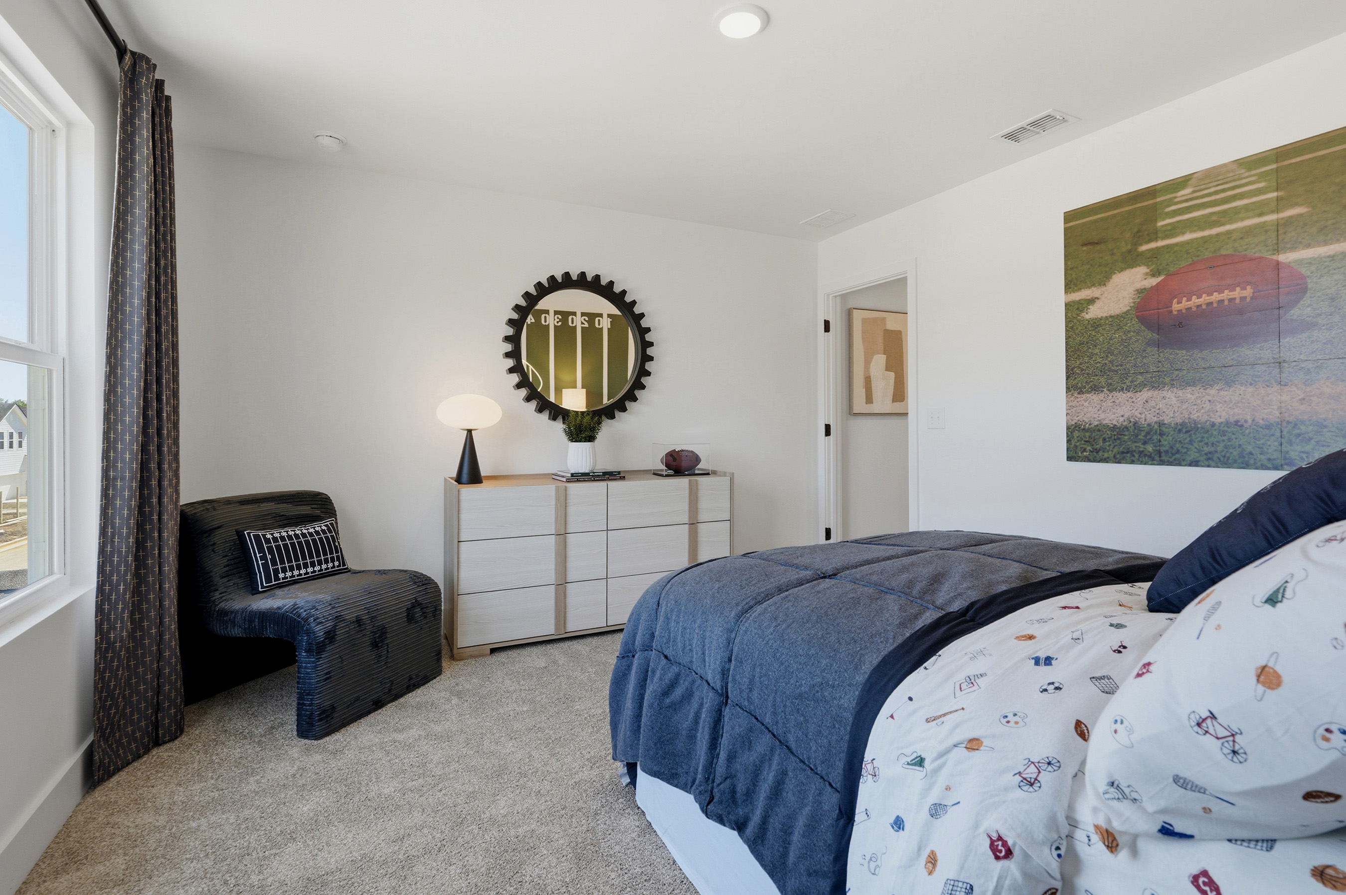 A bedroom with a bed and a chair.