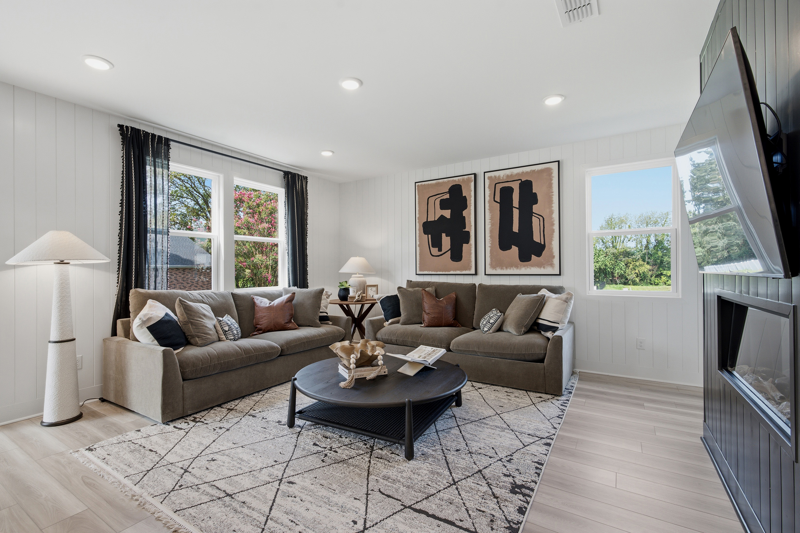 A living room with a large television and couches.