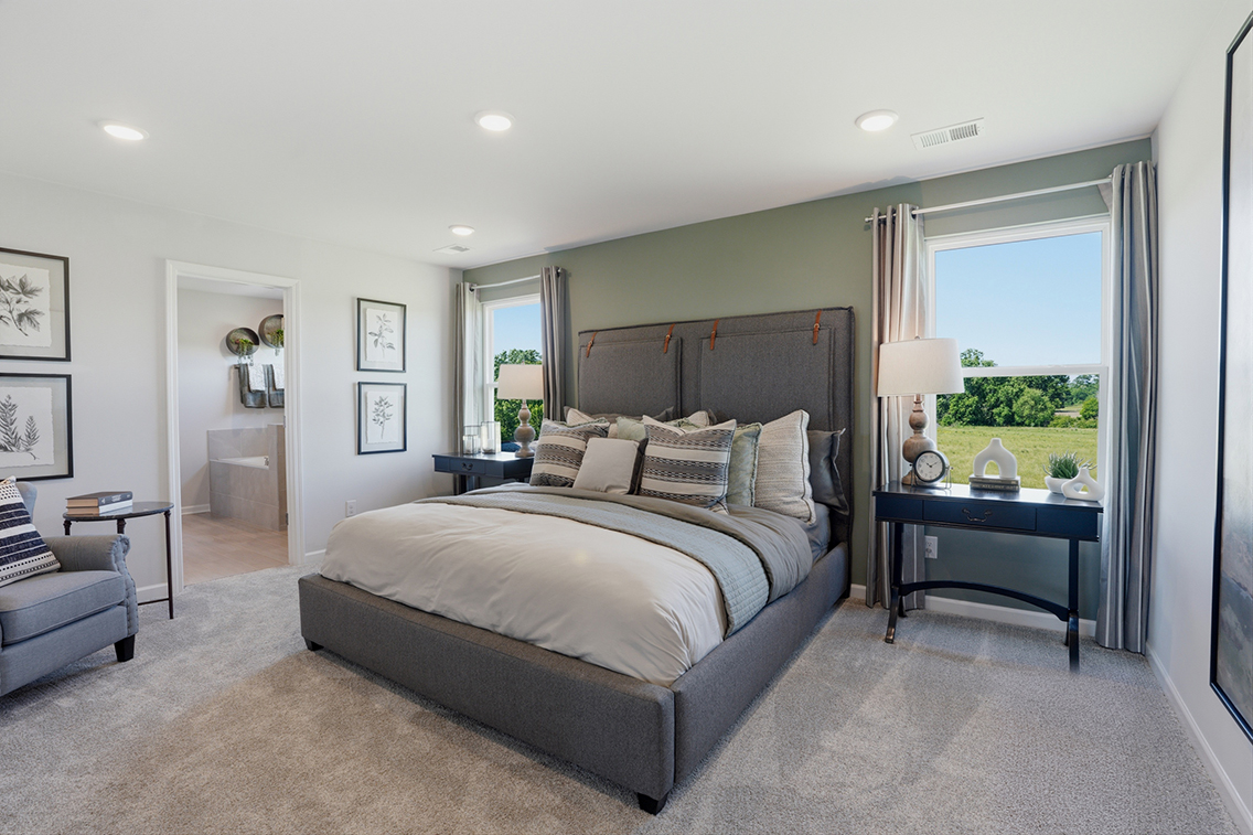 A bedroom with a bed and a lamp.