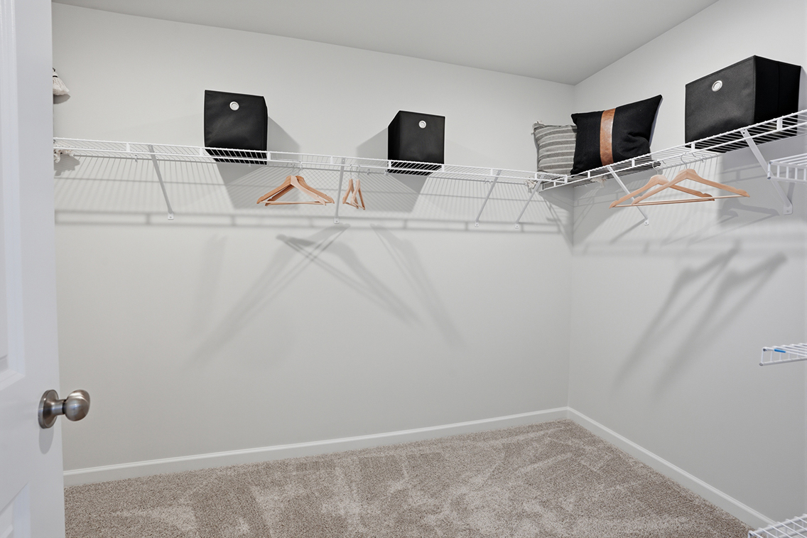A white room with a bed and a tv.