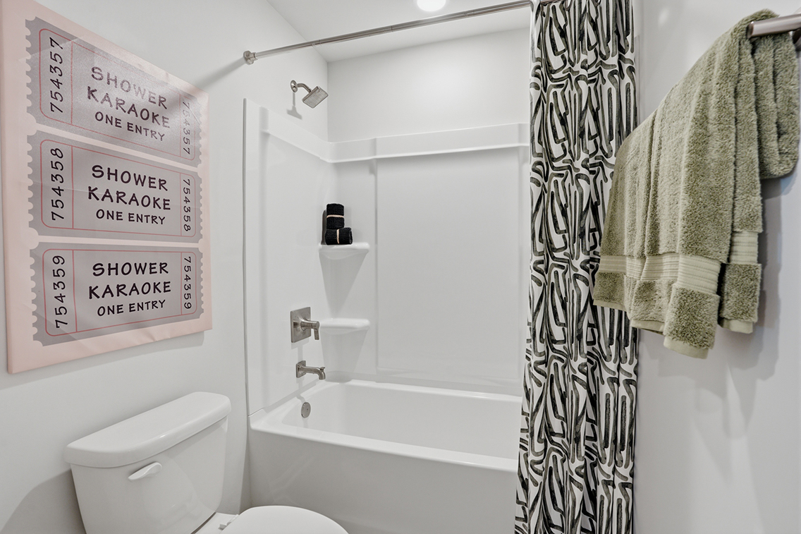 A bathroom with a shower curtain and a toilet.