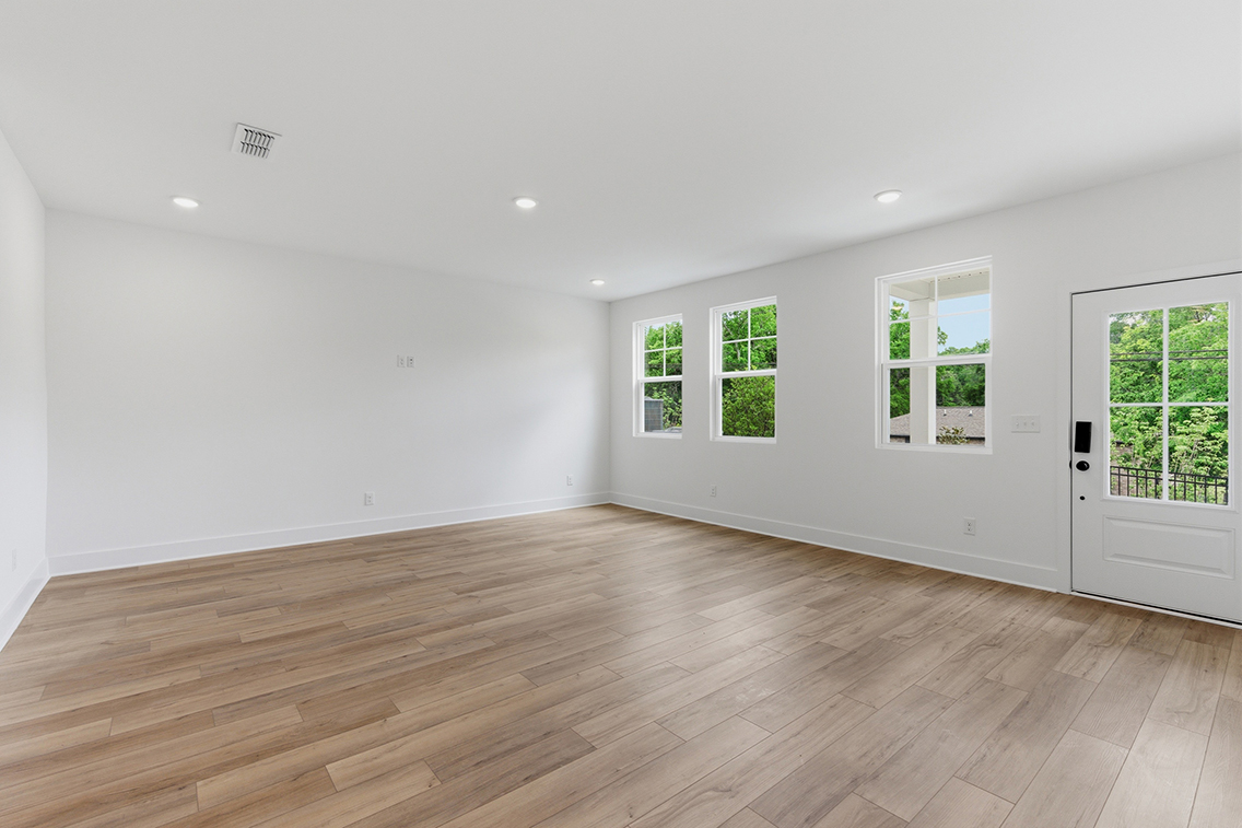 A room with windows and wood floors.