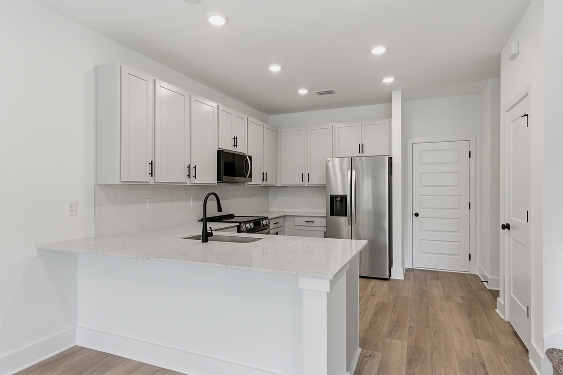 A kitchen with white cabinets.