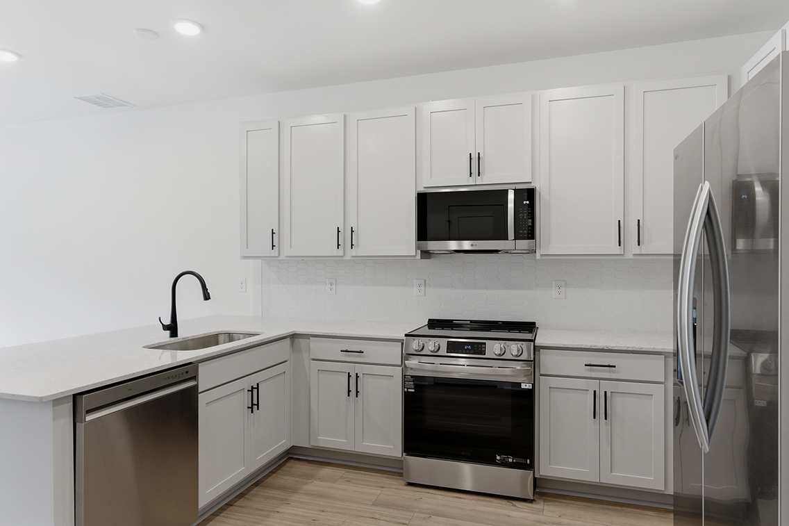 A kitchen with white cabinets.