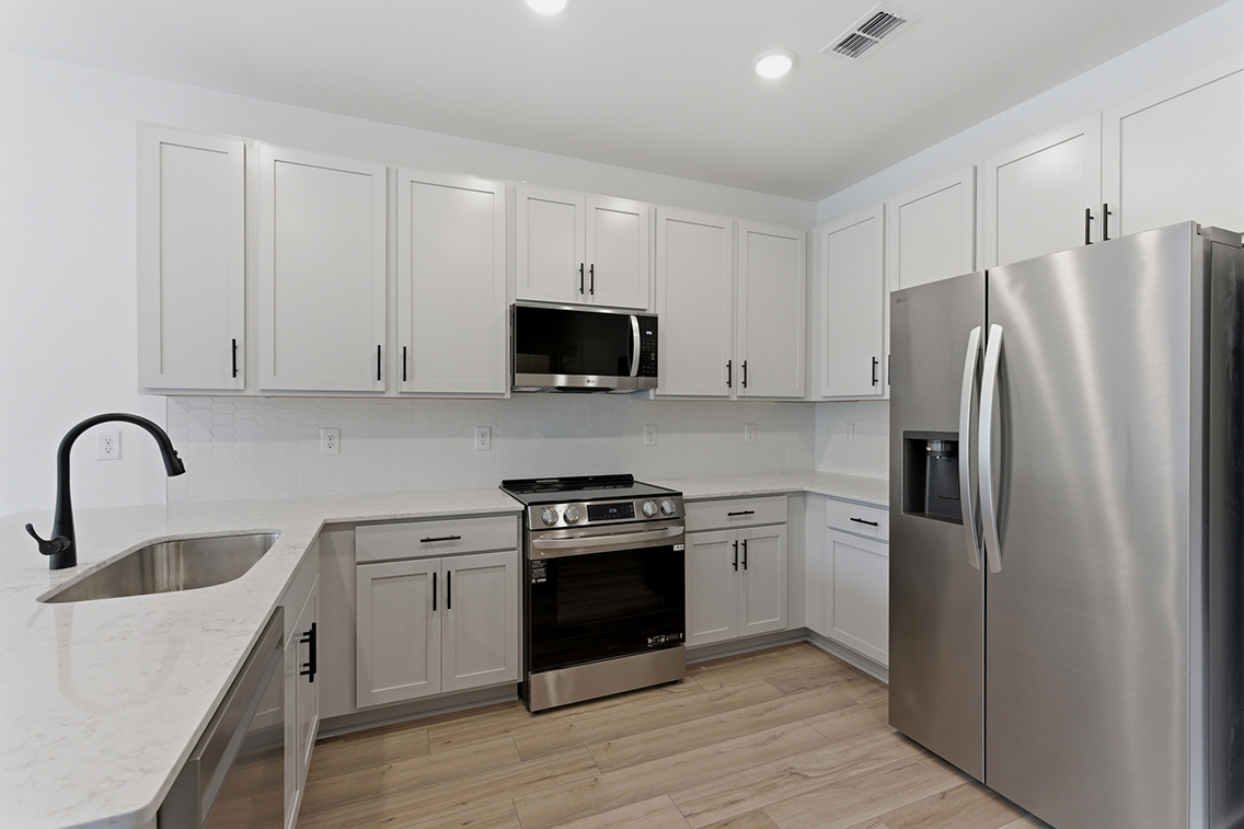 A kitchen with white cabinets.
