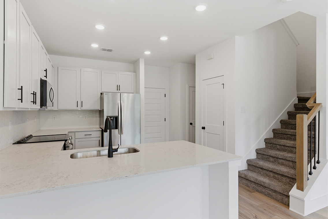 A kitchen with white cabinets.