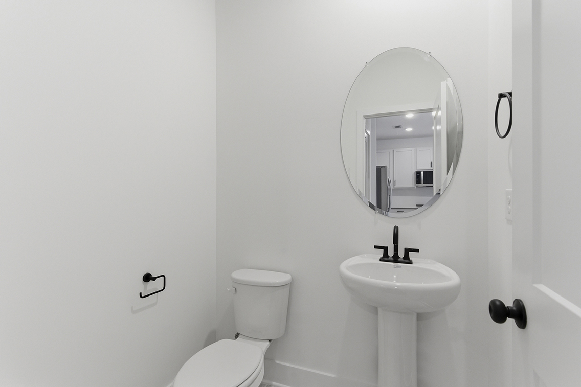 A bathroom with a round mirror.