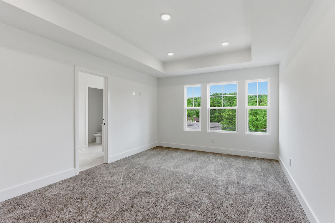 A room with a carpet and a window.