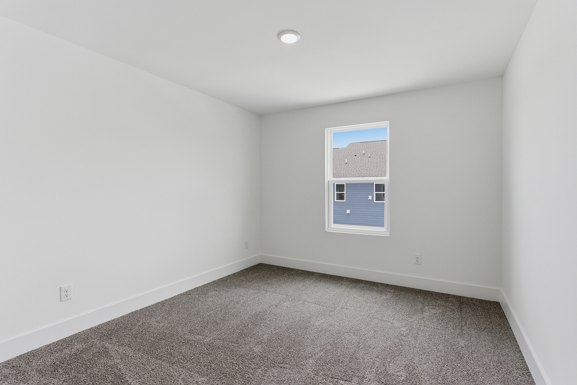 A room with a window and carpet.