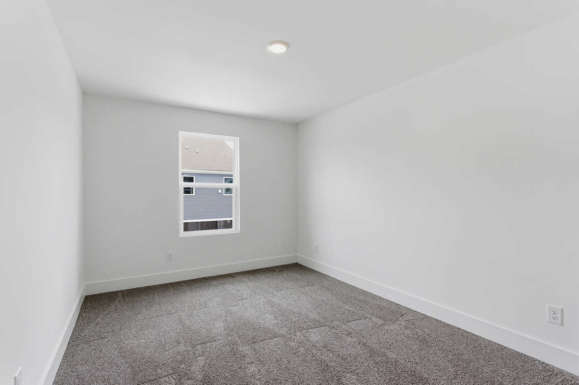 A room with a window and a carpet.