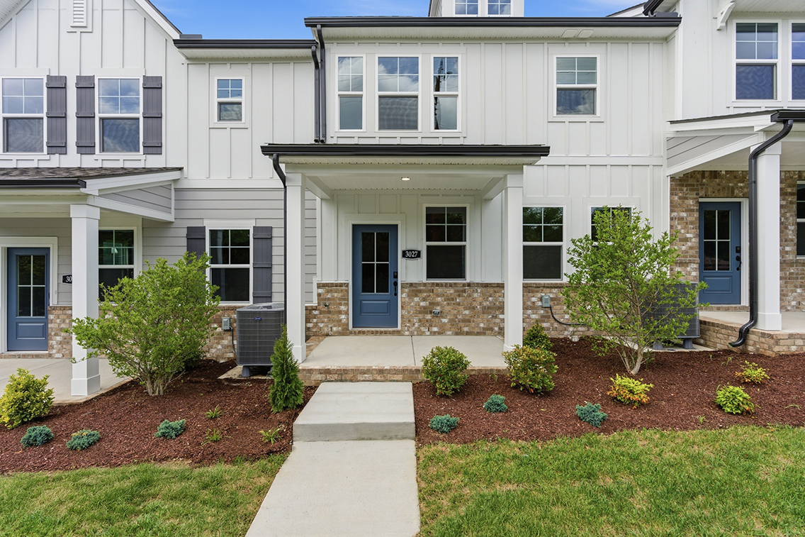 A white building with a green lawn.