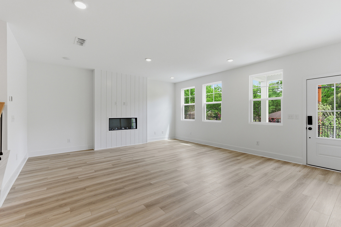A large empty room with a wood floor and white walls.