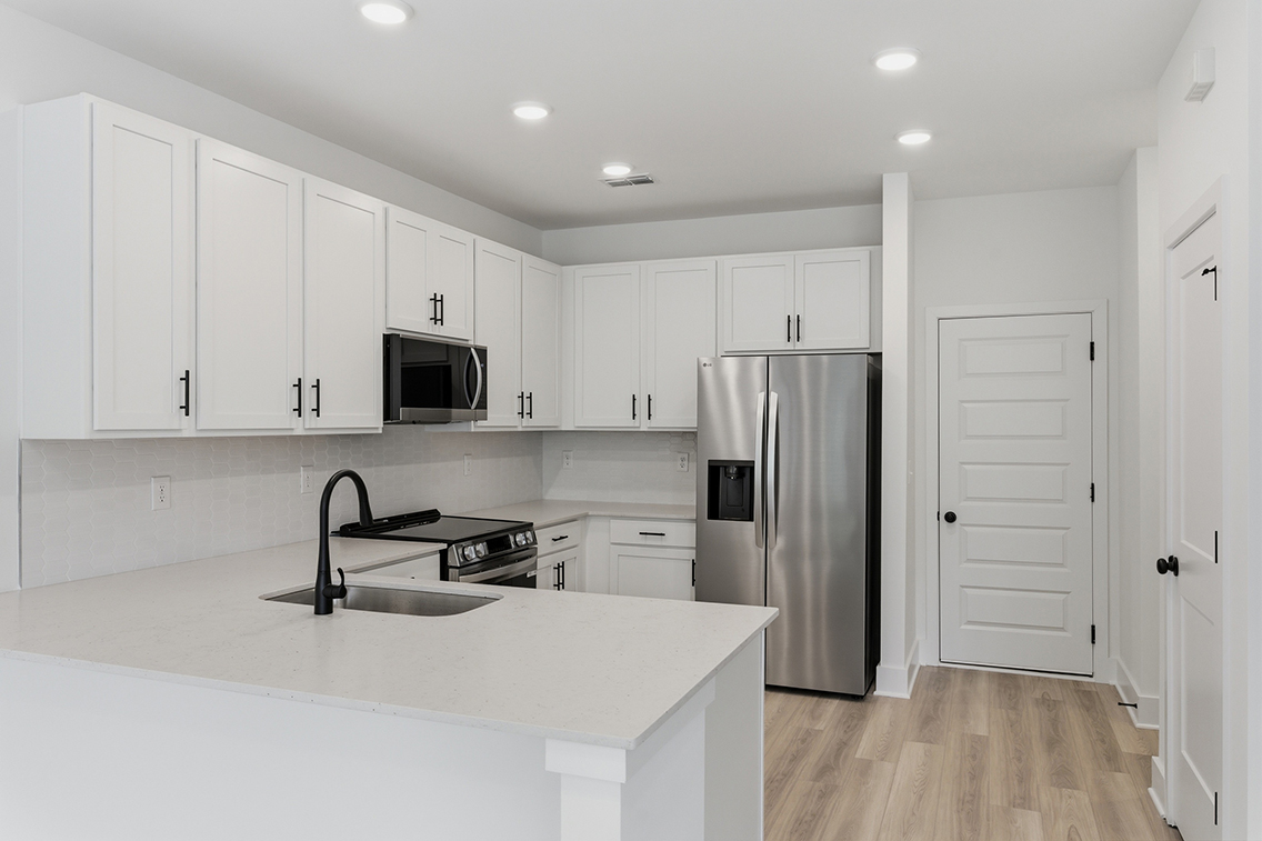 A kitchen with white cabinets.