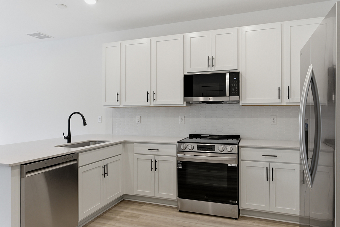 A kitchen with white cabinets.