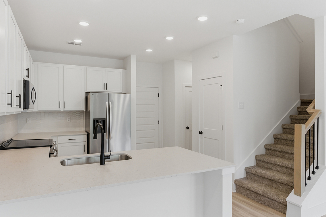 A kitchen with white cabinets.