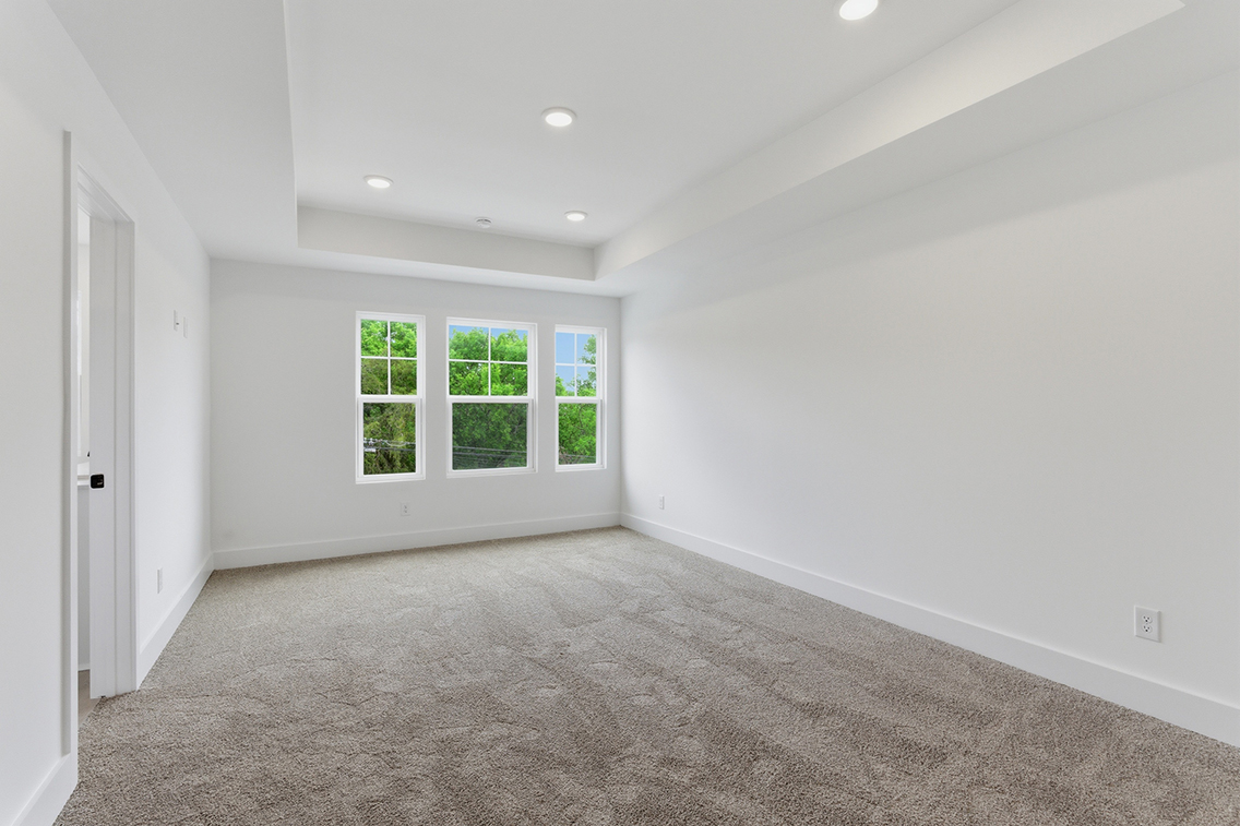 A room with a carpet and windows.