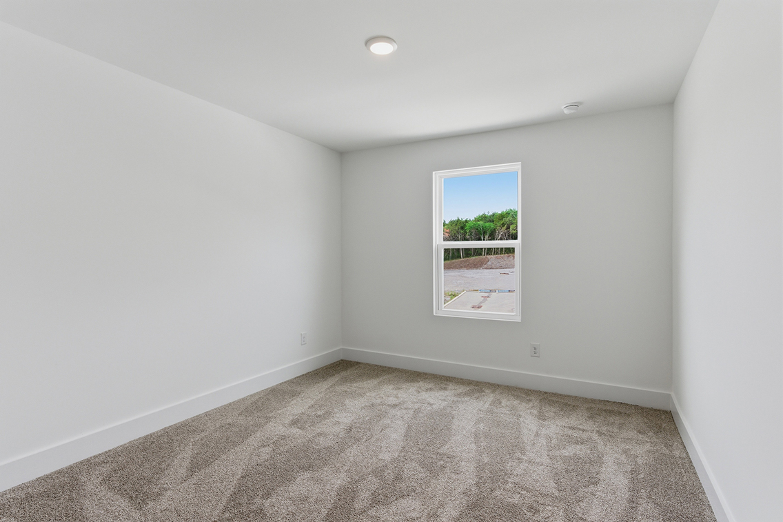 A room with a window and a carpet.
