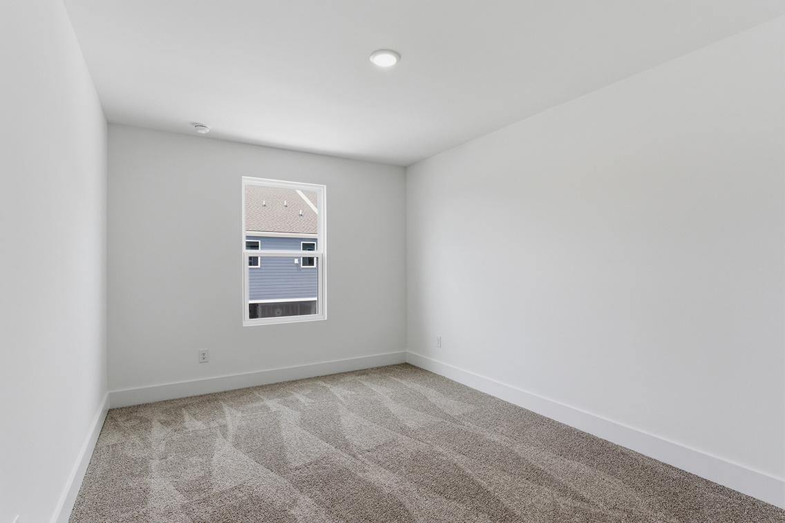 A room with a window and a rug.