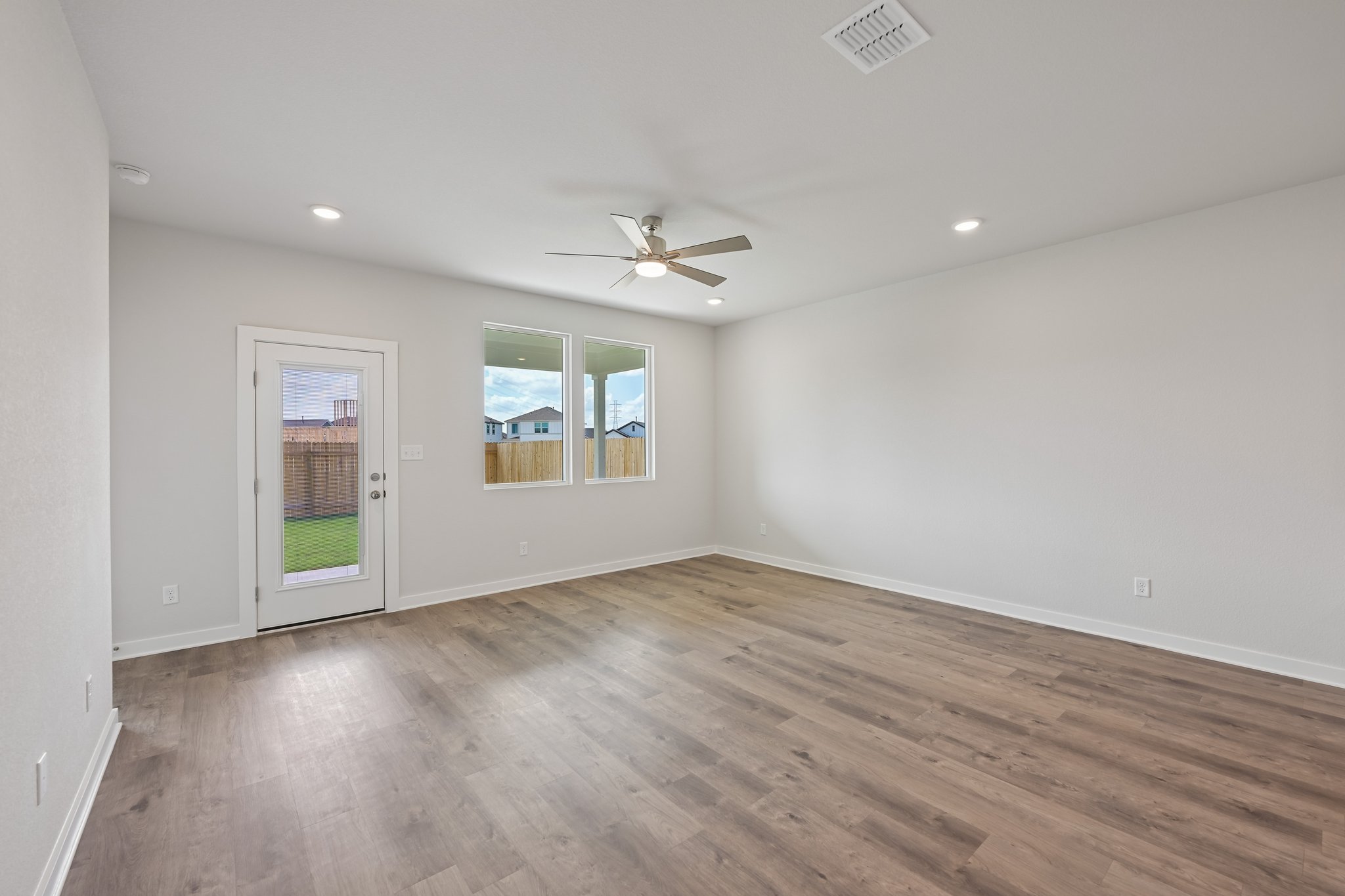 A room with a wood floor and a ceiling fan.