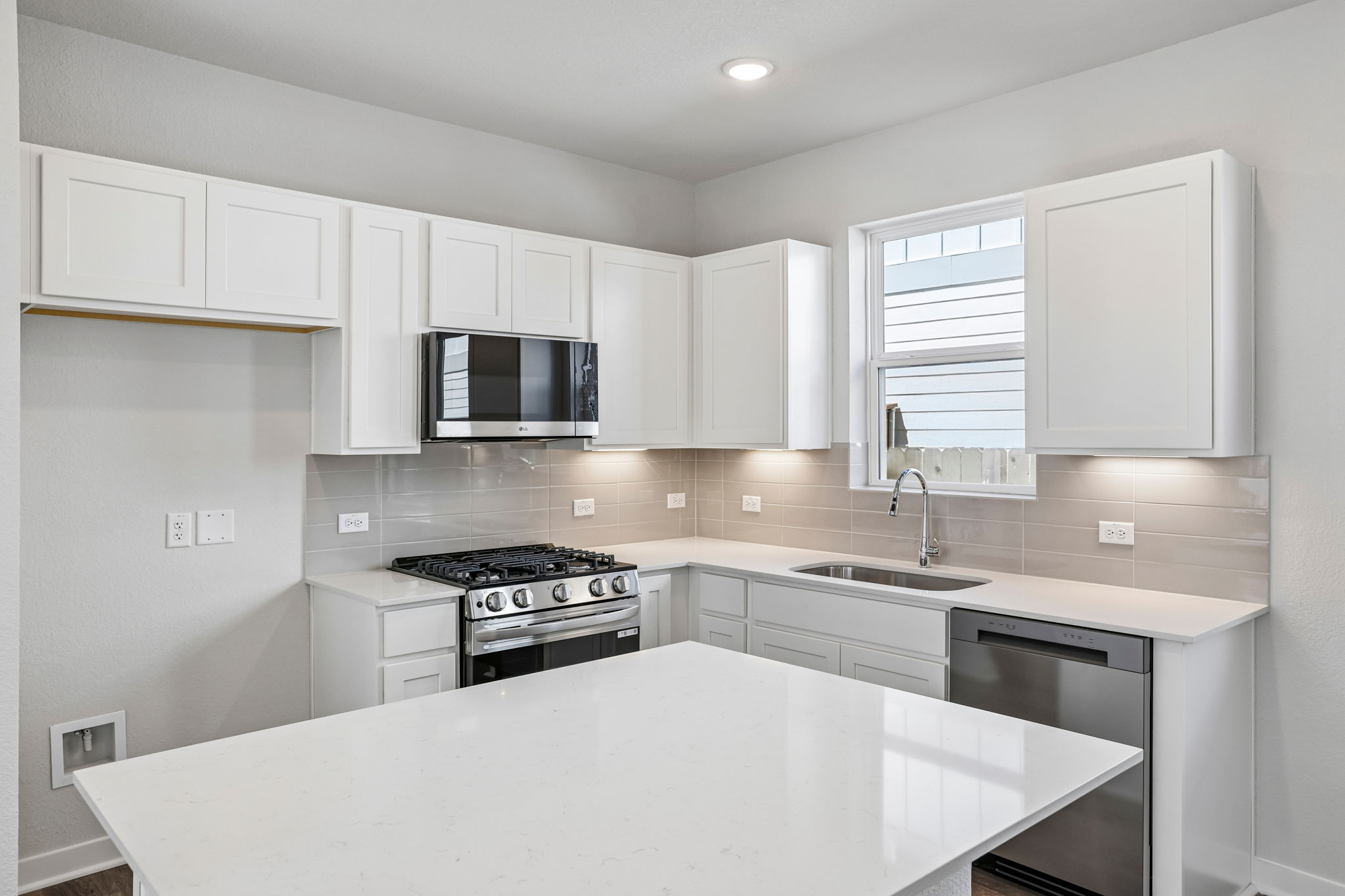 A kitchen with white cabinets.