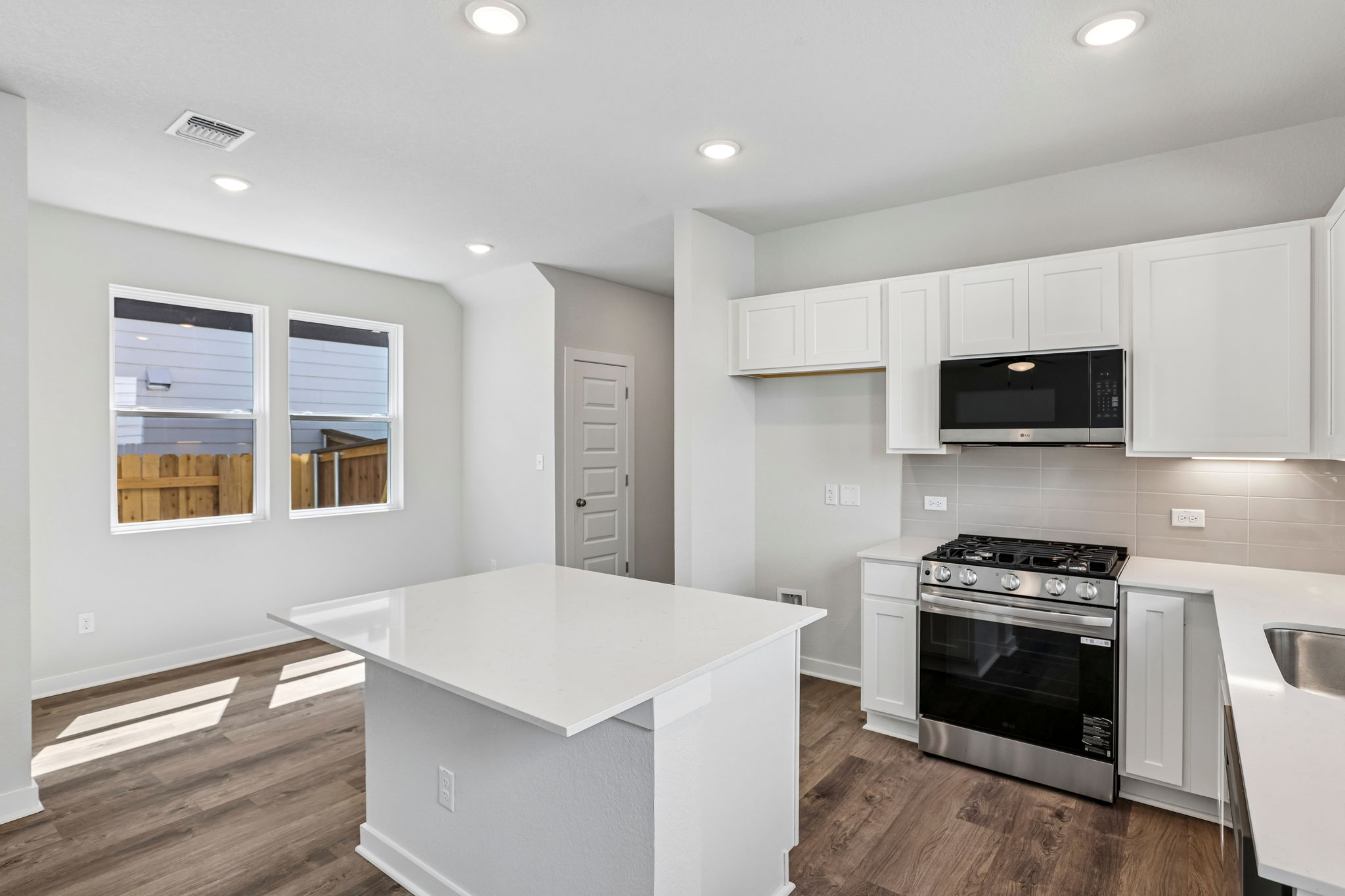 A kitchen with white cabinets.