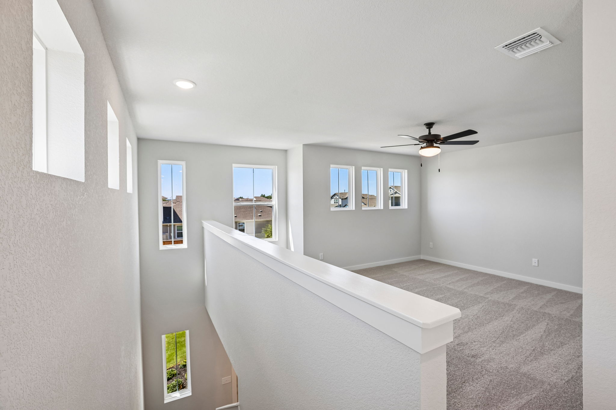 A room with a ceiling fan and a window.