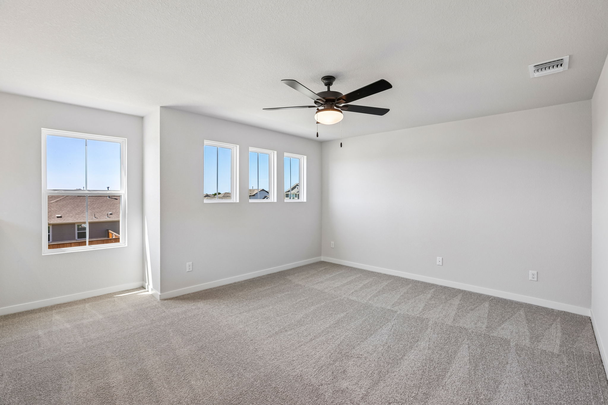 A room with a ceiling fan and a window.
