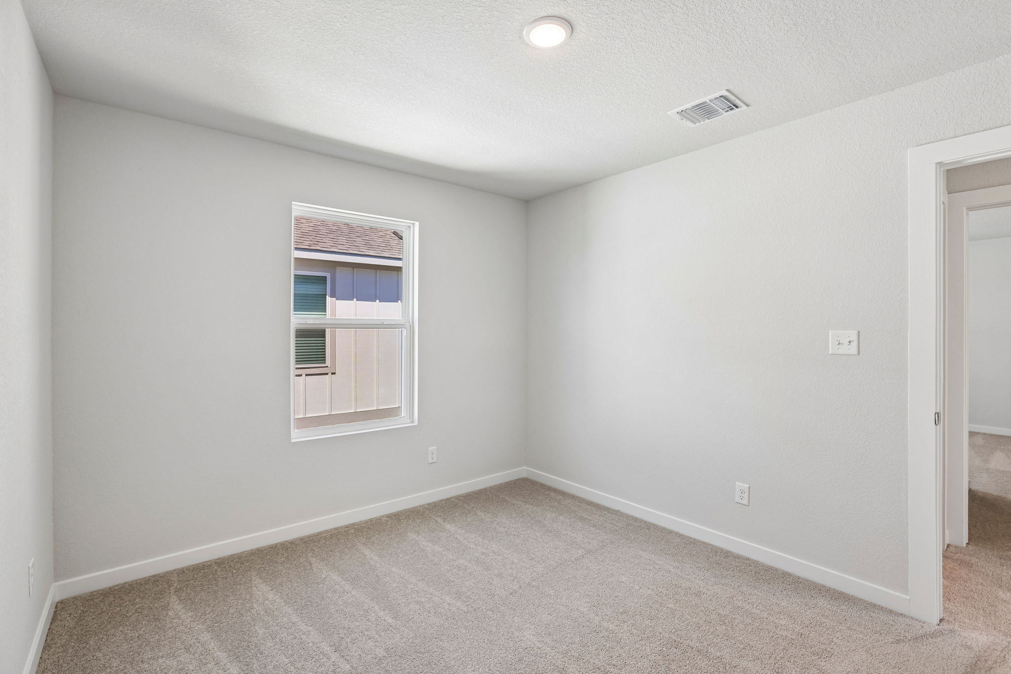 A room with a window and carpet.