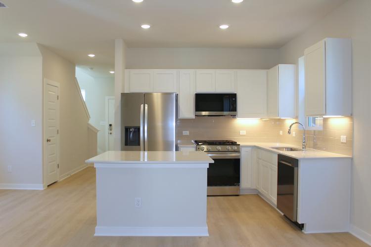 A kitchen with white cabinets.