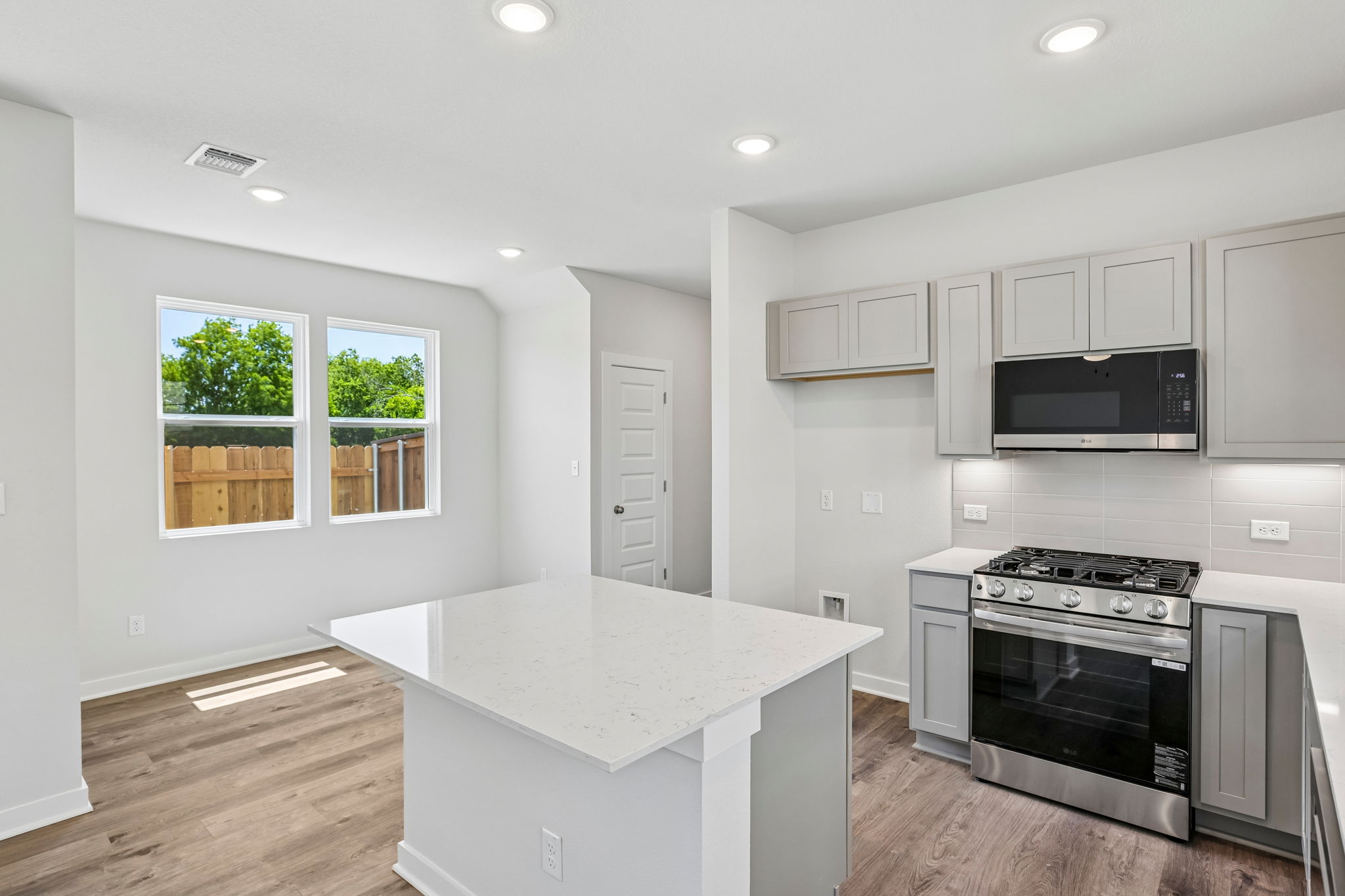A kitchen with white cabinets.