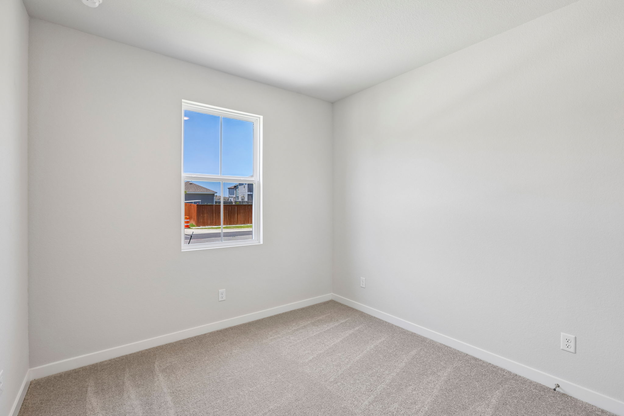 A room with a window and a carpet.