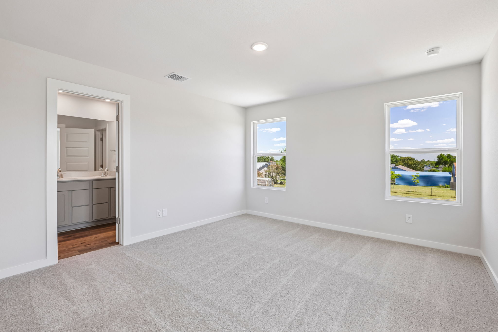 A room with a white wall and a door with a window.