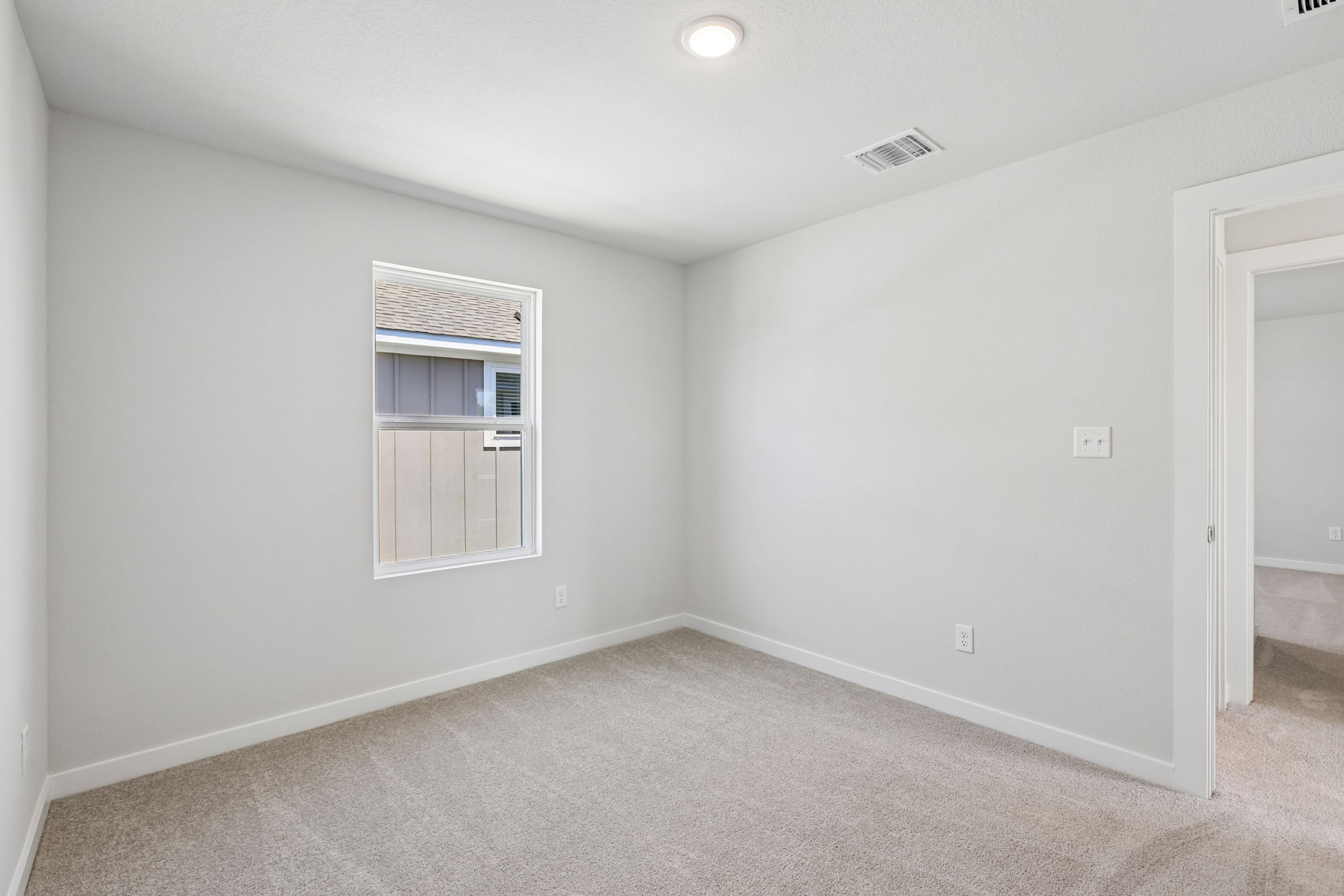 A room with a window and a carpet.