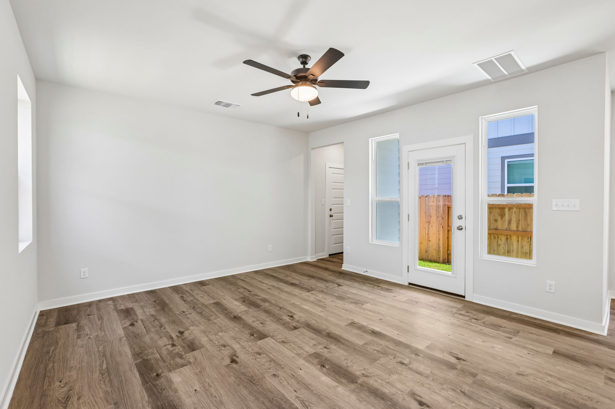 A room with a wood floor and a ceiling fan.