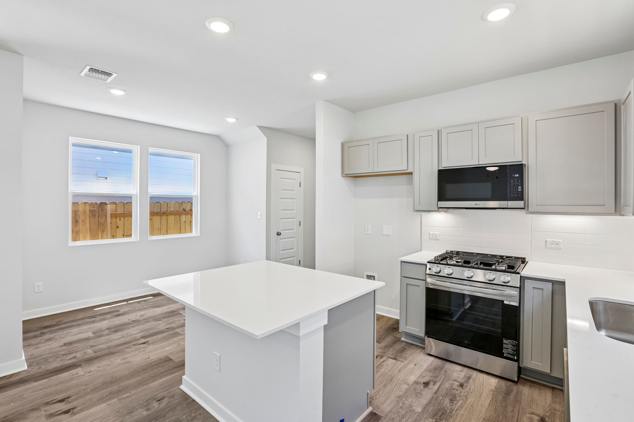 A kitchen with white cabinets.