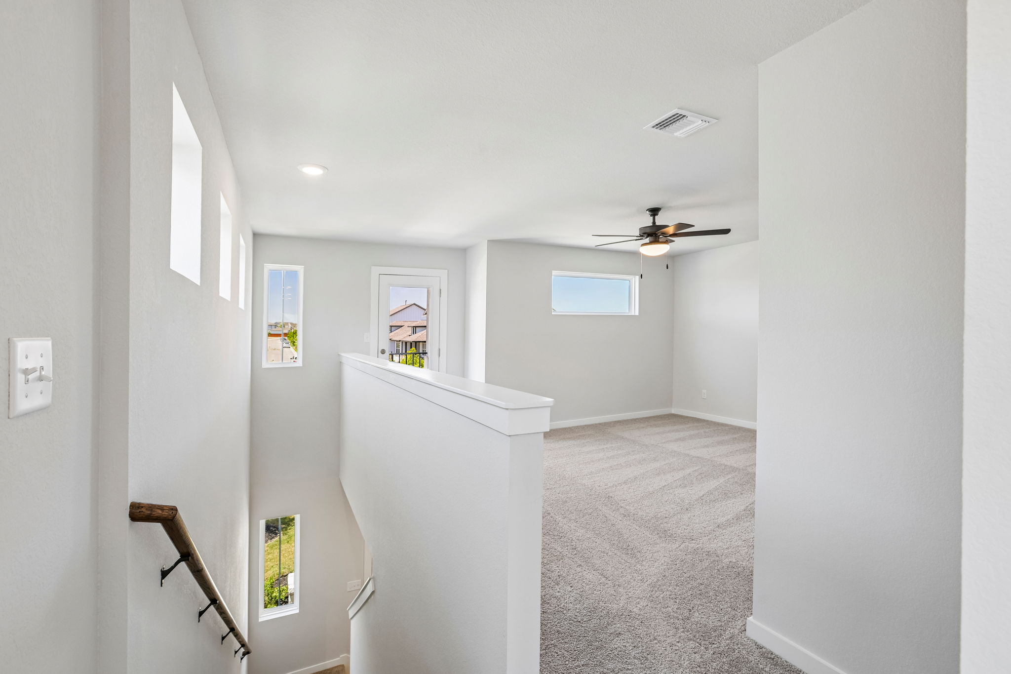 A hallway with a fan and a window.