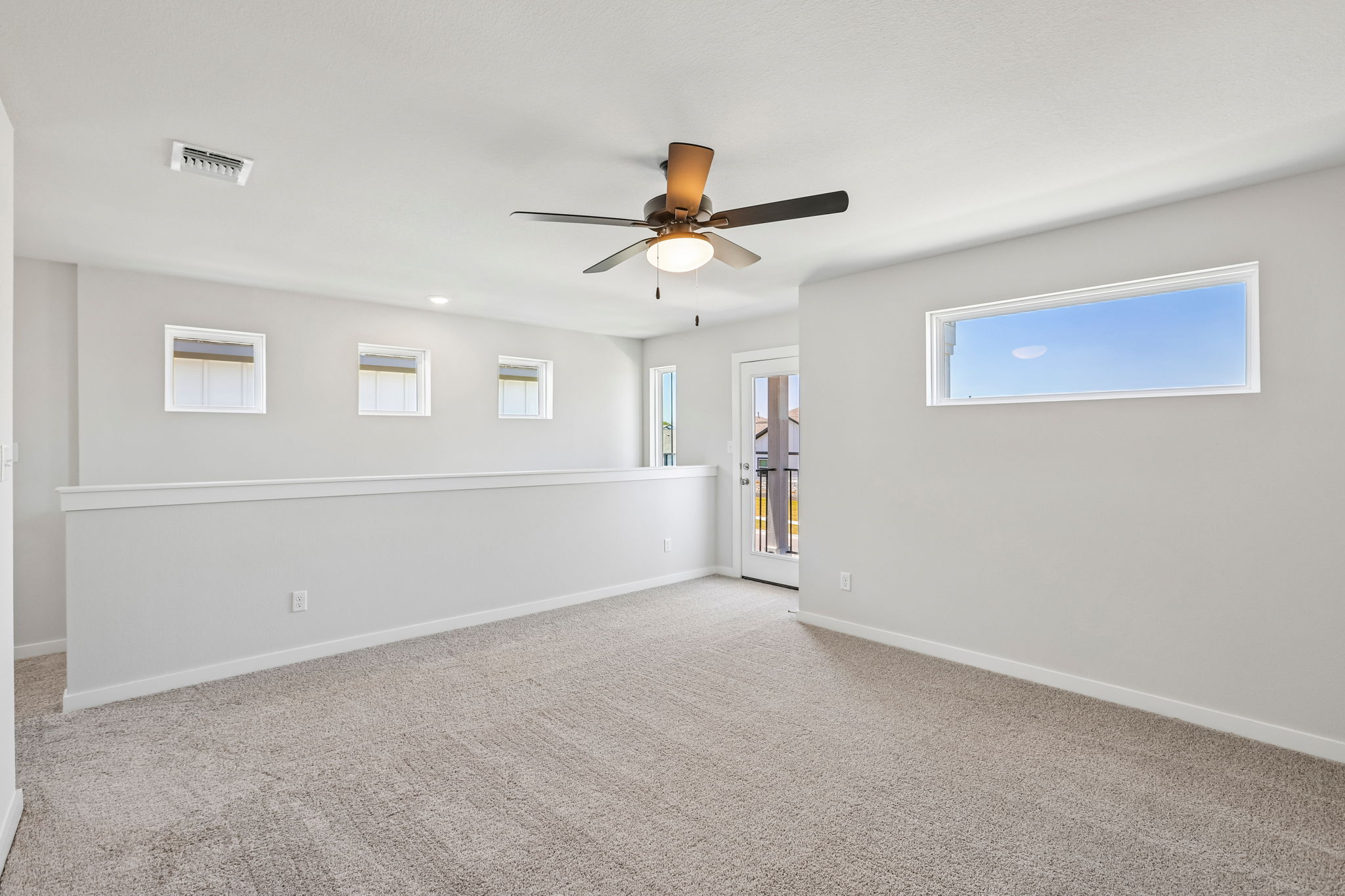A room with a ceiling fan and a door.
