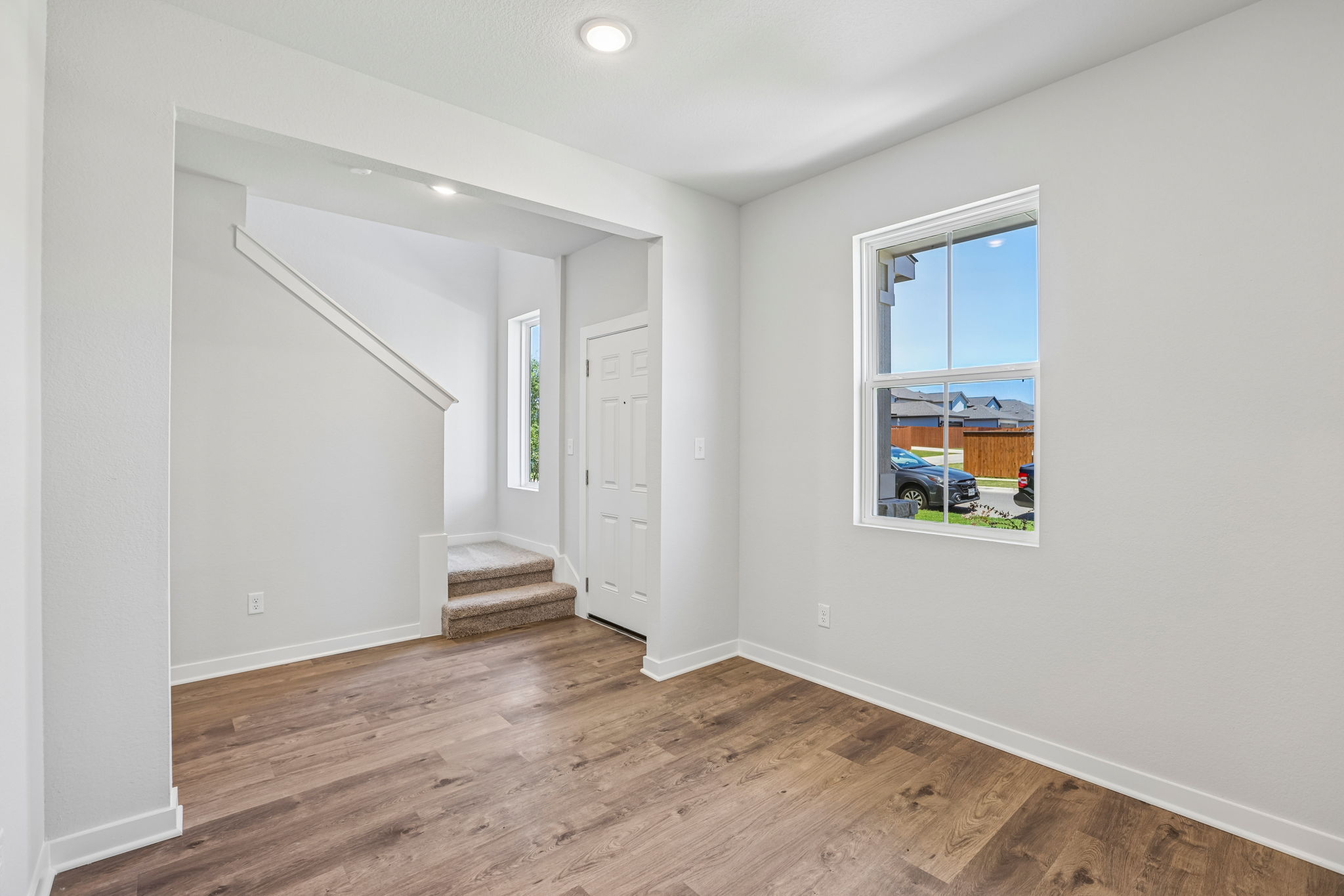A room with a wood floor and a window.