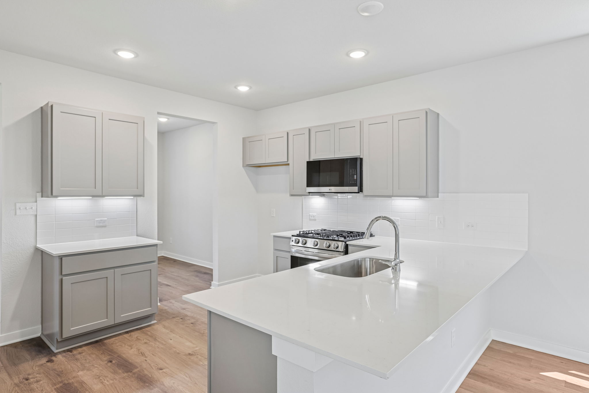 A kitchen with white cabinets.