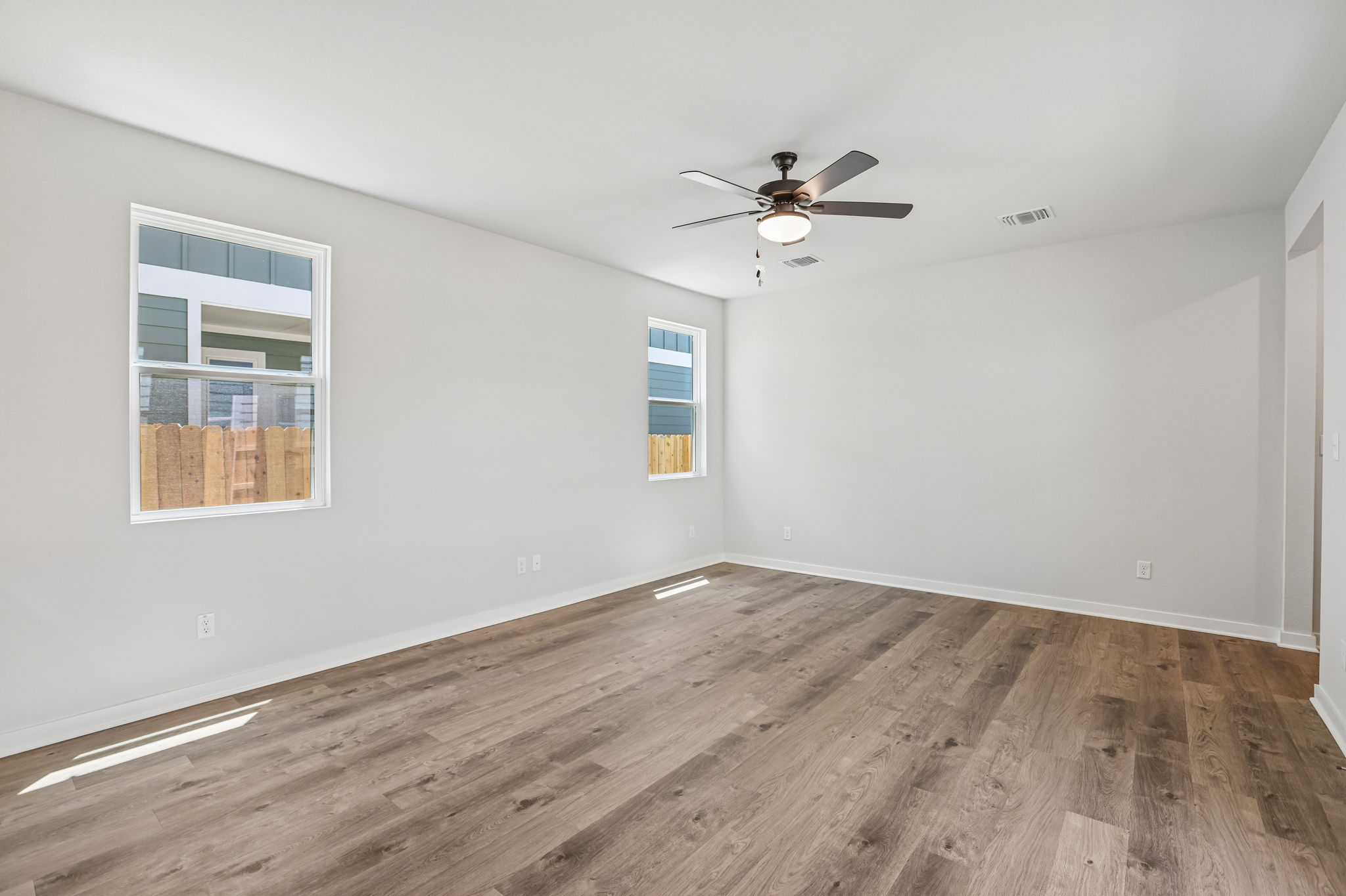 A room with a wood floor and a ceiling fan.