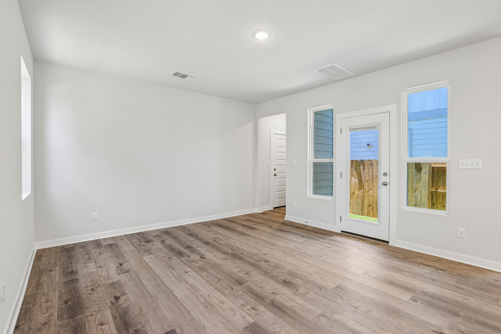 A room with white walls and wood floors.